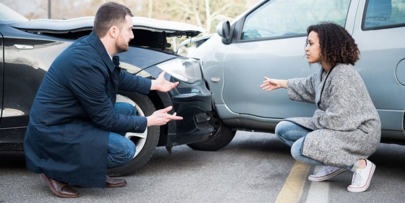 Man and woman arguing about damage after bad car crash